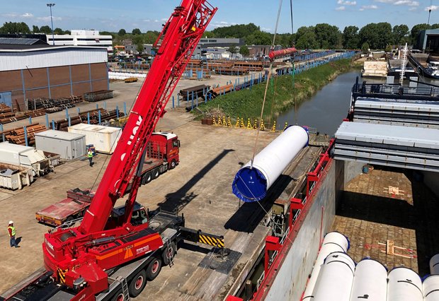 Déchargement de gros tubes en acier avec une grue chez Van Leeuwen à Zwijndrecht.